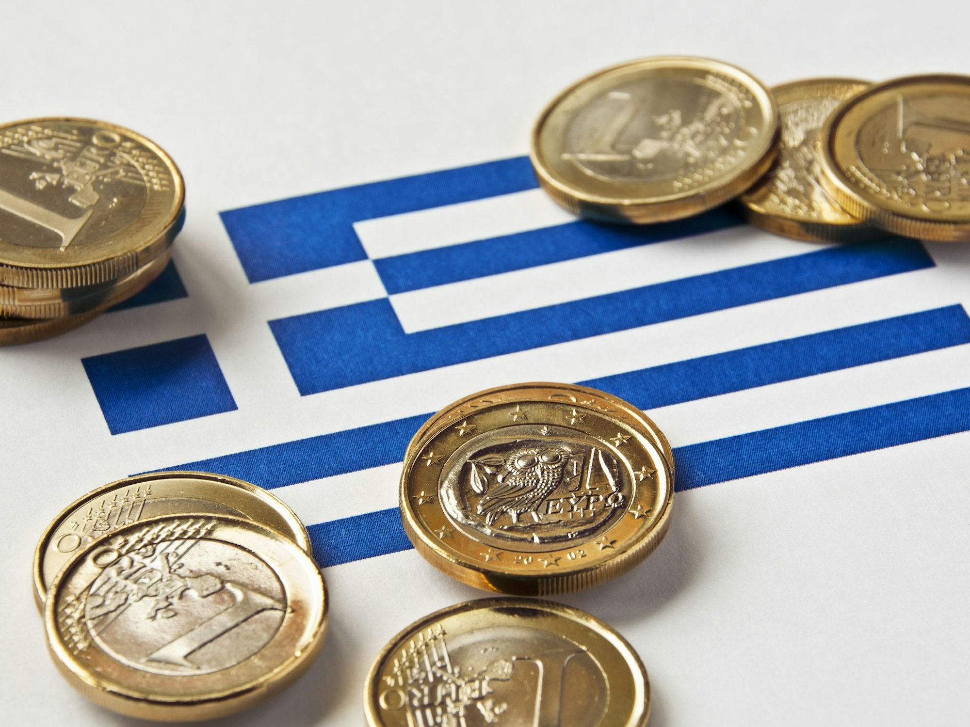 Trinkgeld liegt auf einer Griechenlandflagge.