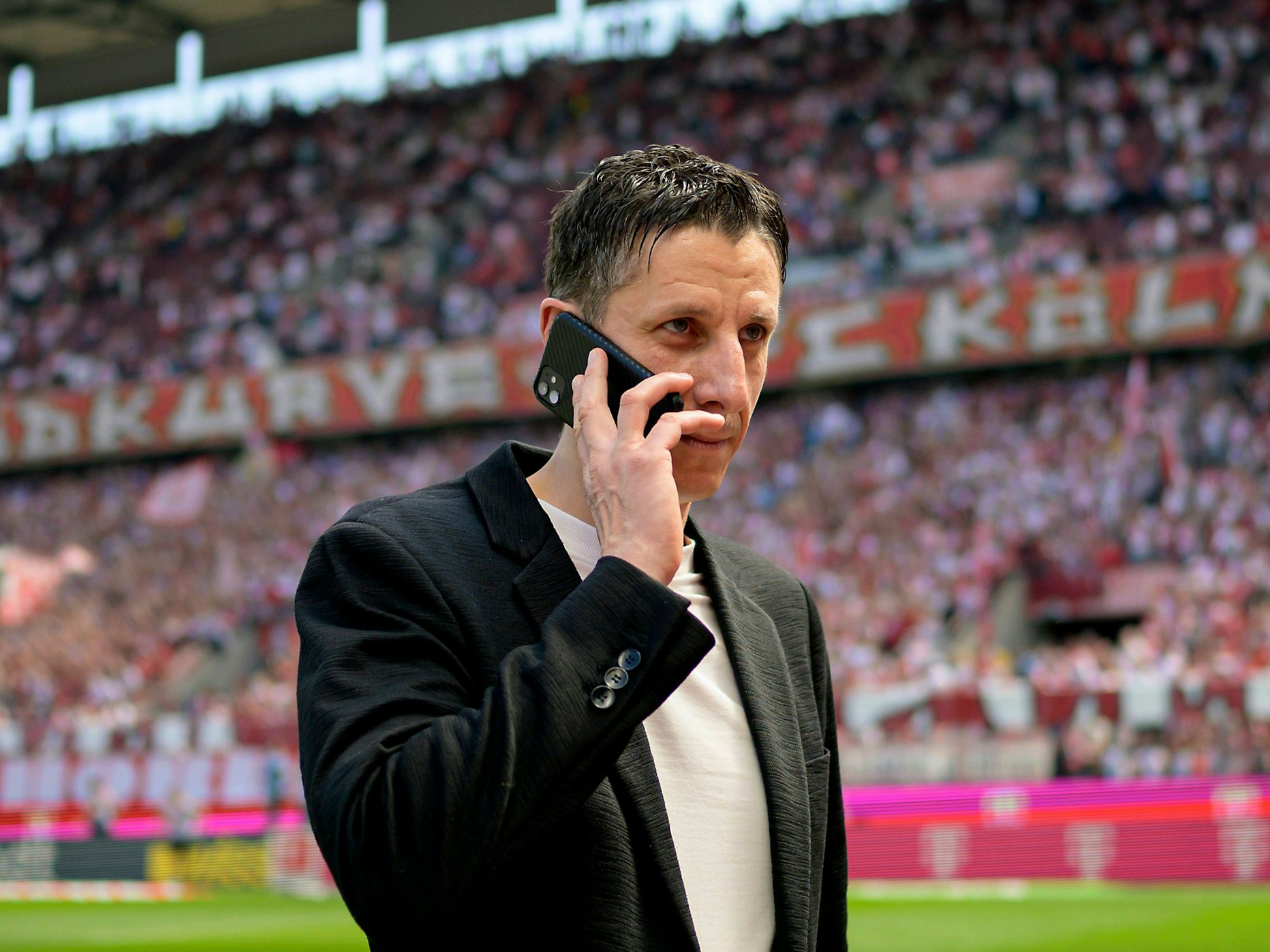 Christian Keller telefoniert im Rhein-Energie-Stadion.