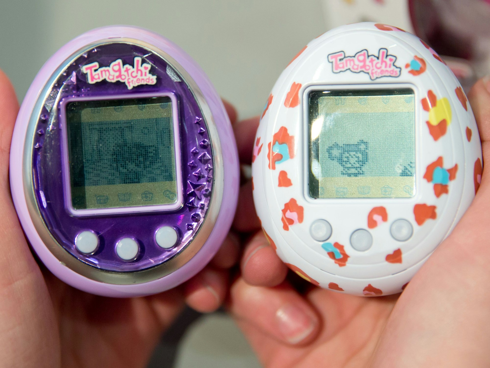 Zwei Tamagotchis des Herstellers Bandai werden während der 65. Internationalen Spielwarenmesse in Händen gehalten, hier im Januar 2014 in Nürnberg.