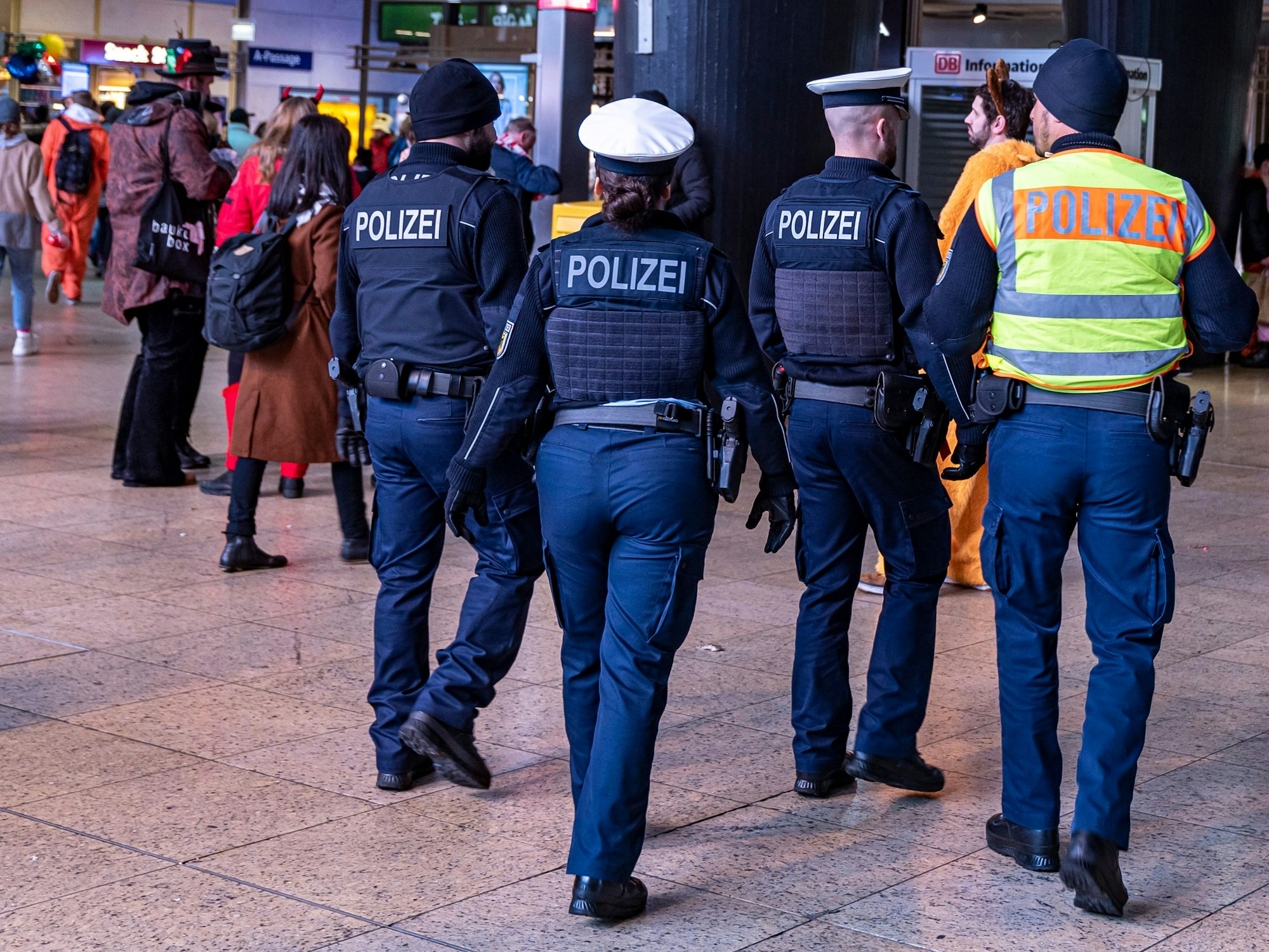 Vier Einsatzkräfte der Bundespolizei patrouillieren im Kölner Hauptbahnhof.