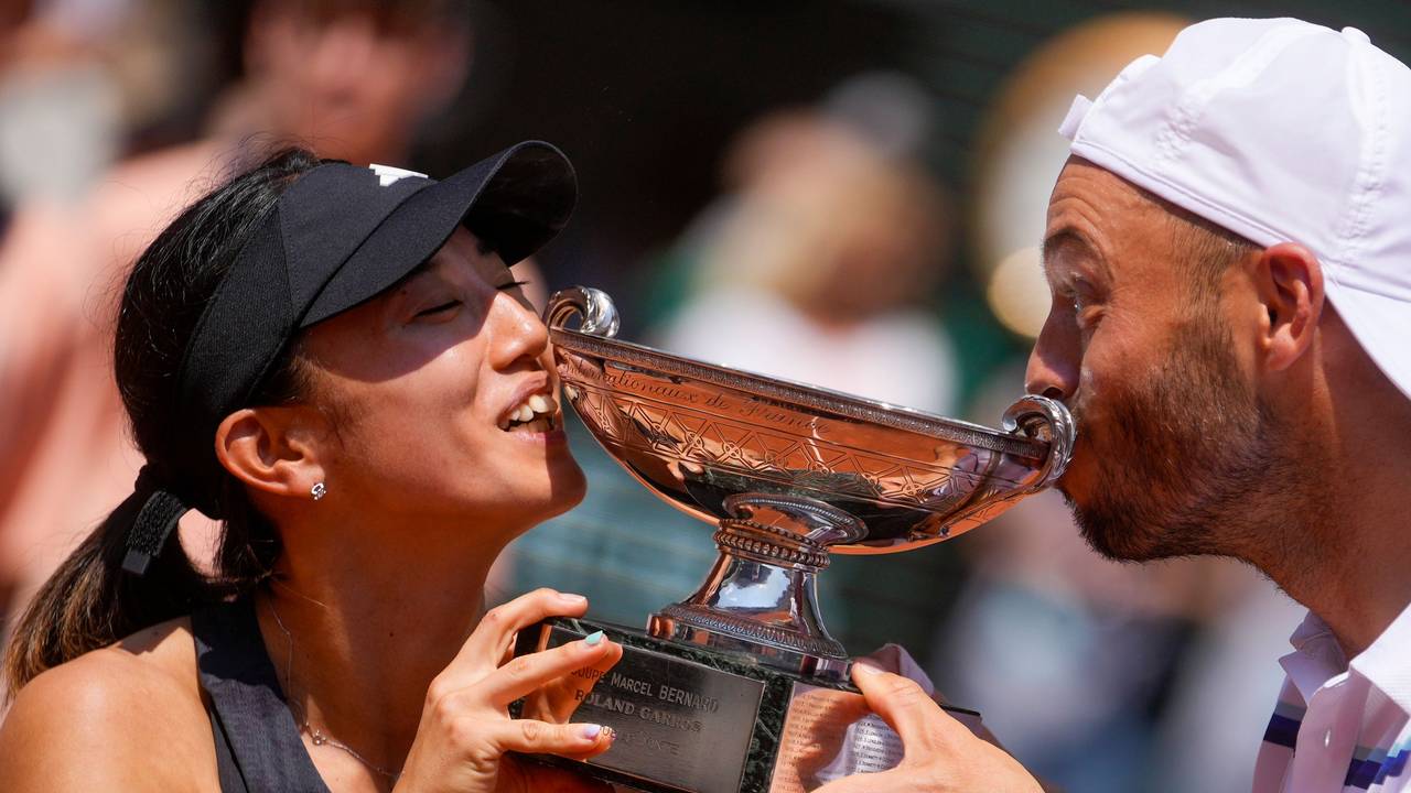 Tim Pütz und Miyu Kato küssen die Trophäe.