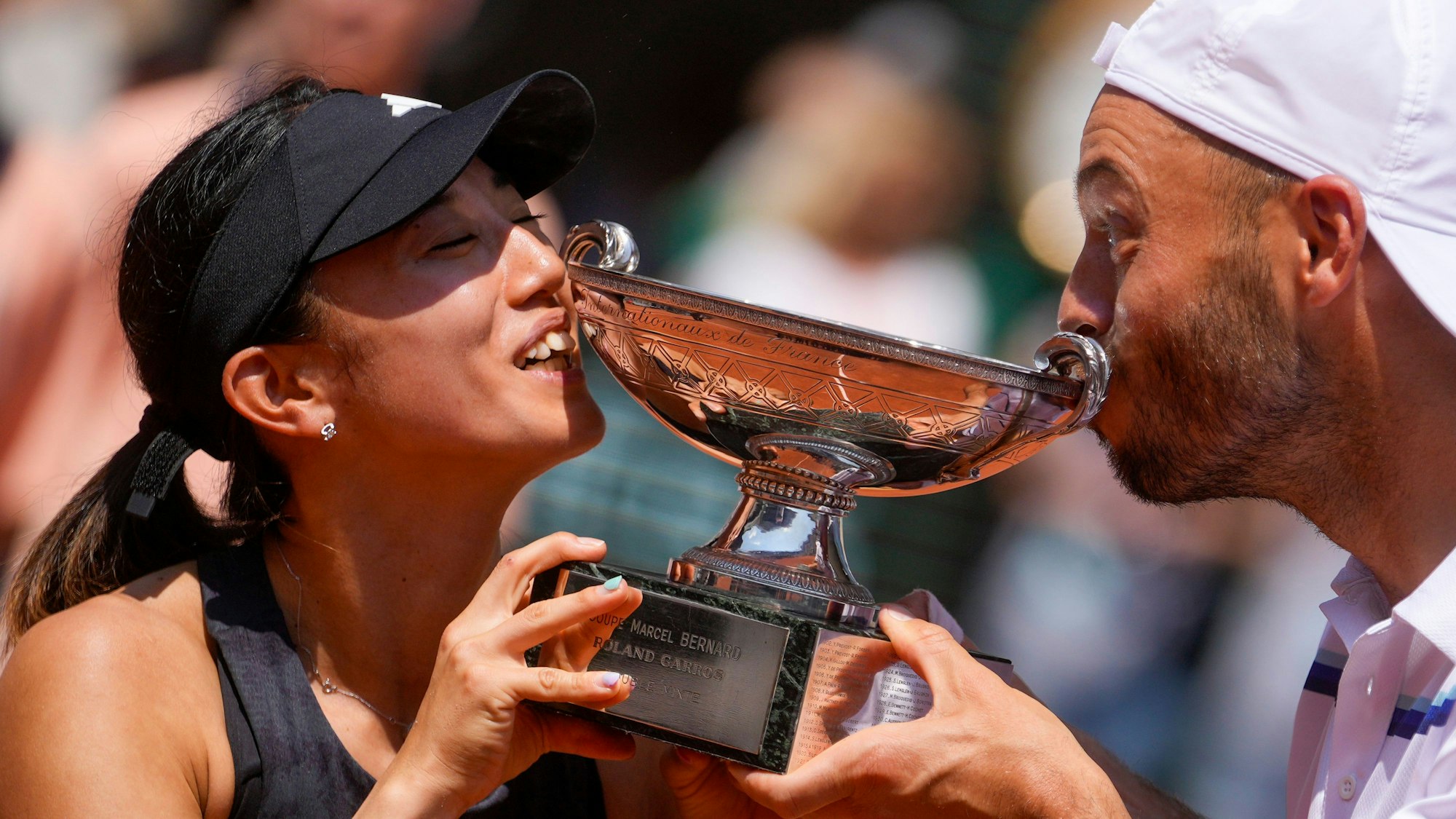 Tim Pütz und Miyu Kato küssen die Trophäe.