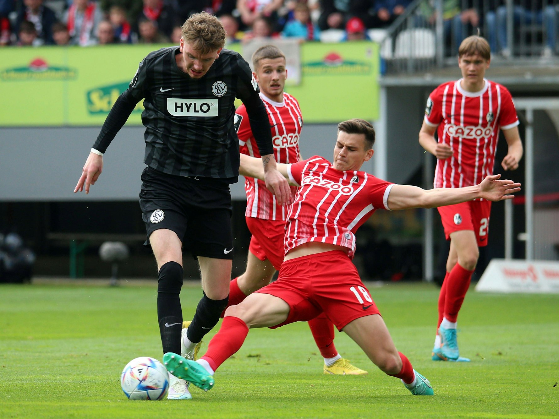 Freiburgs Yannik Engelhardt grätscht gegen Nock Woltemade.