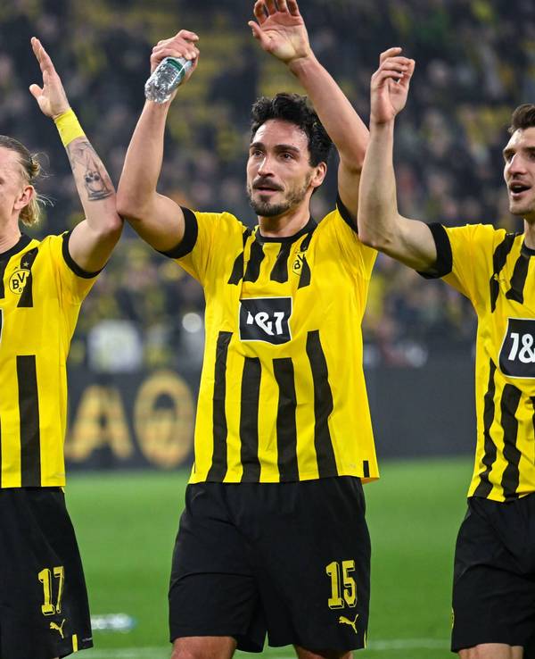 Marius Wolf, Mats Hummels und Thomas Meunier jubeln gemeinsam vor den Fans.