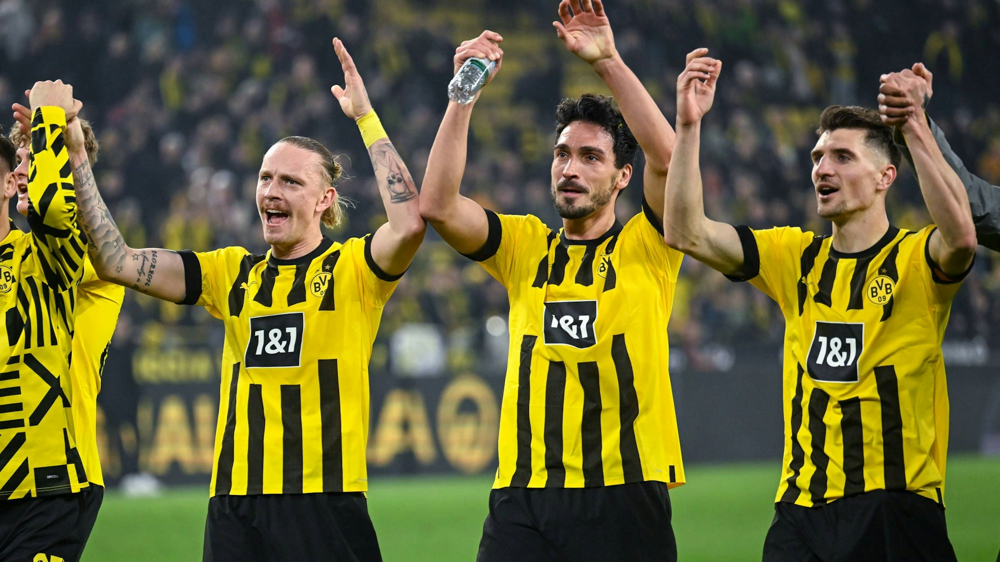 Marius Wolf, Mats Hummels und Thomas Meunier jubeln gemeinsam vor den Fans.
