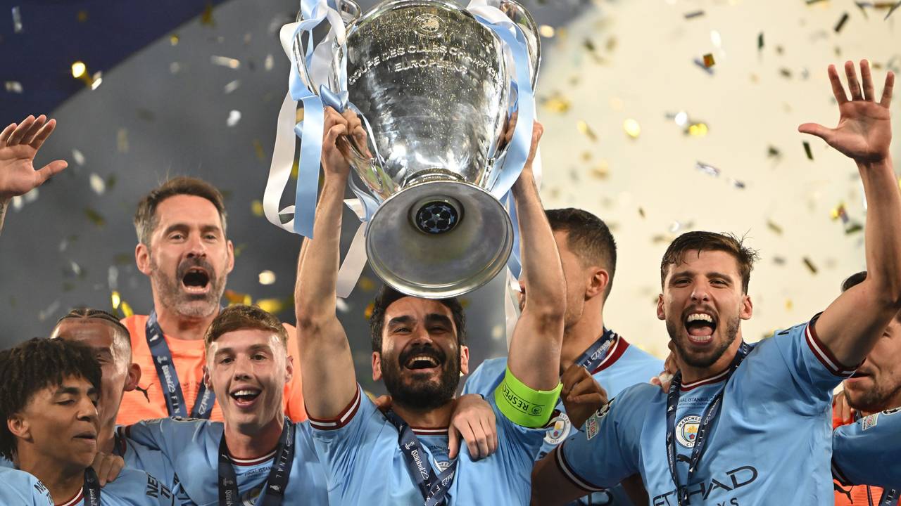 Ilkay Gündogan (M) jubelt bei der Siegerehrung mit der Trophäe.