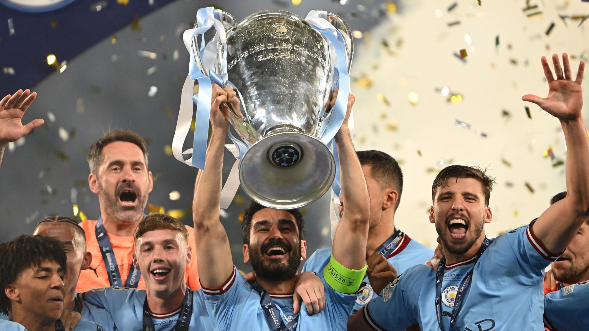Ilkay Gündogan (M) jubelt bei der Siegerehrung mit der Trophäe.