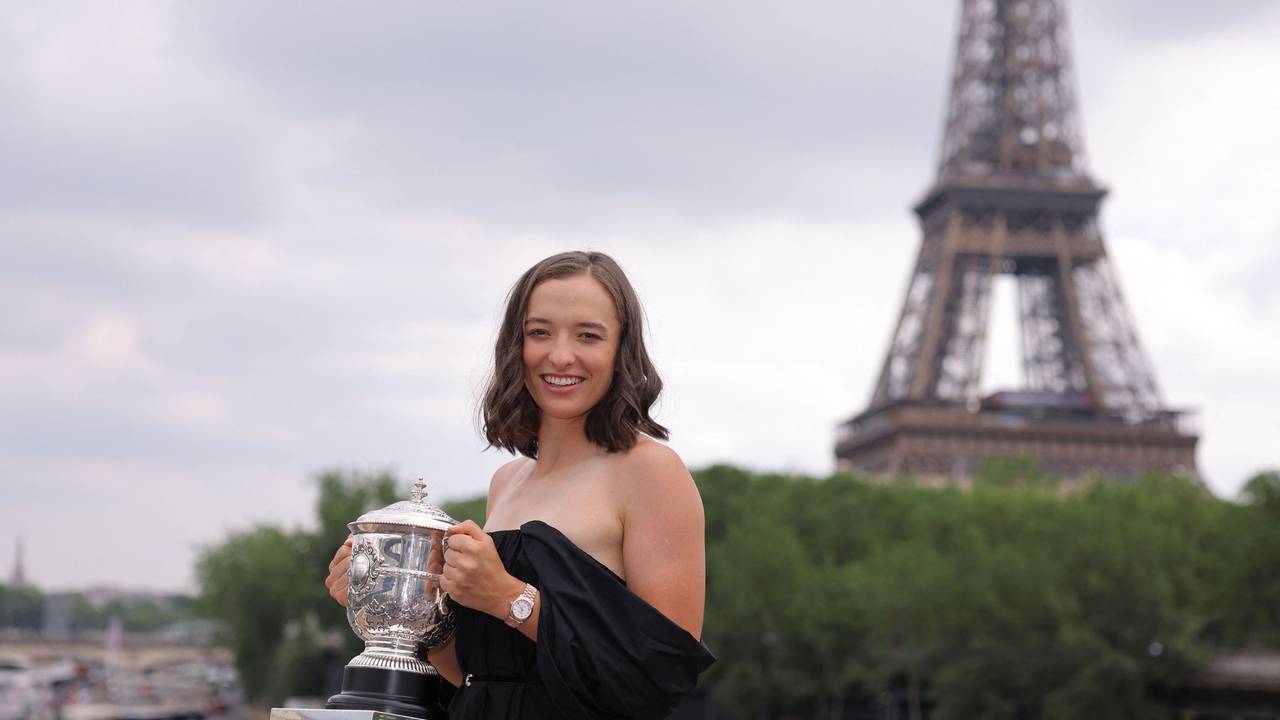 Iga Swiatek posiert mit der Trophäe vor dem Eiffelturm.