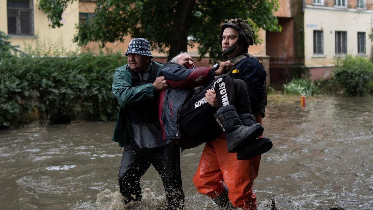 Rettungskräfte bringen am 11. Juni 2023 einen Zivilisten in Sicherheit, der unter Beschuss russischer Streitkräfte geraten war, während er versuchte, mit einem Boot vom russisch besetzten Ostufer des überschwemmten Dnepr in das ukrainisch kontrollierte Cherson am Westufer zu fliehen.