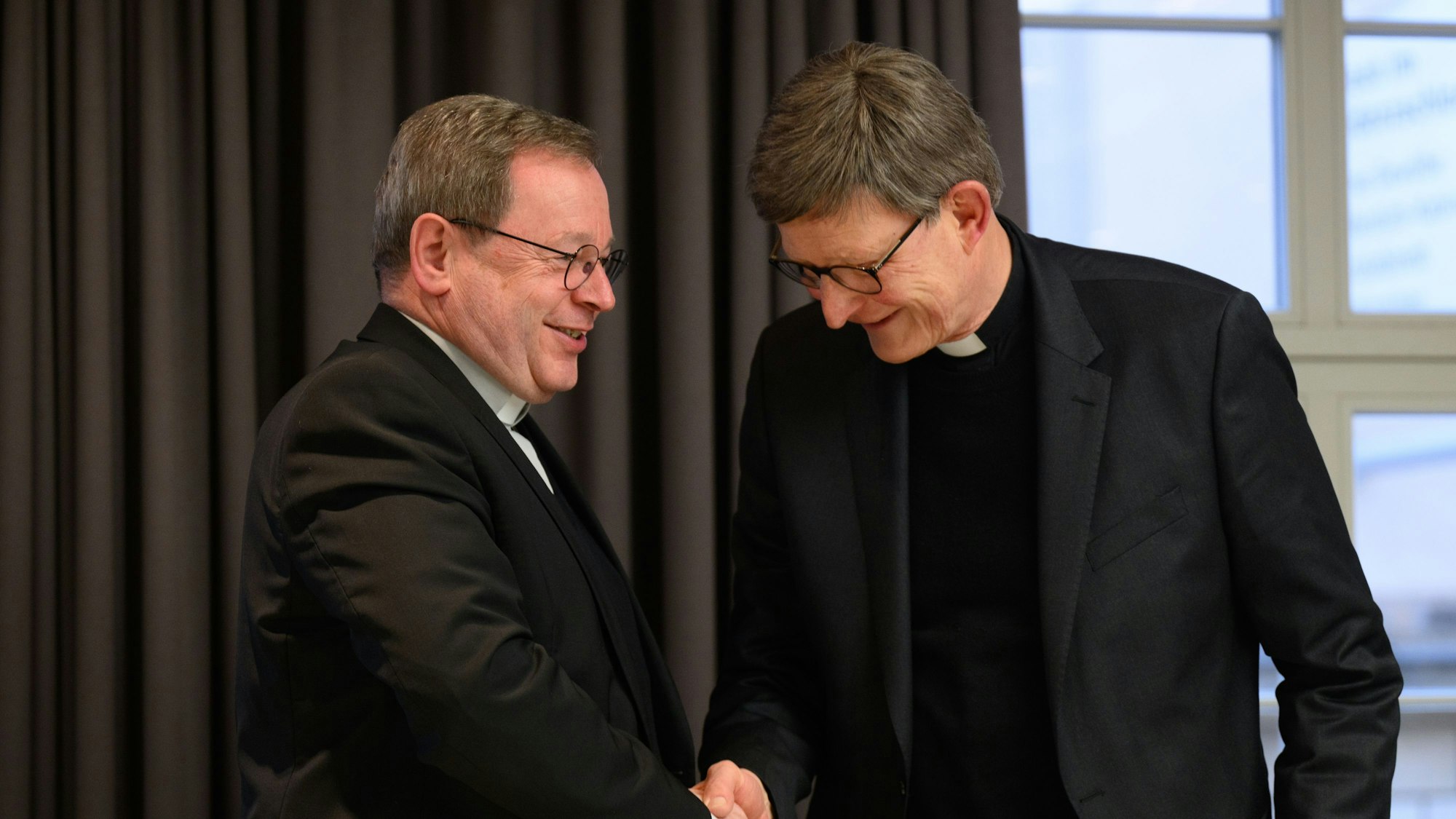 Georg Bätzing und Erzbischof Woelki schütteln sich die Hände.