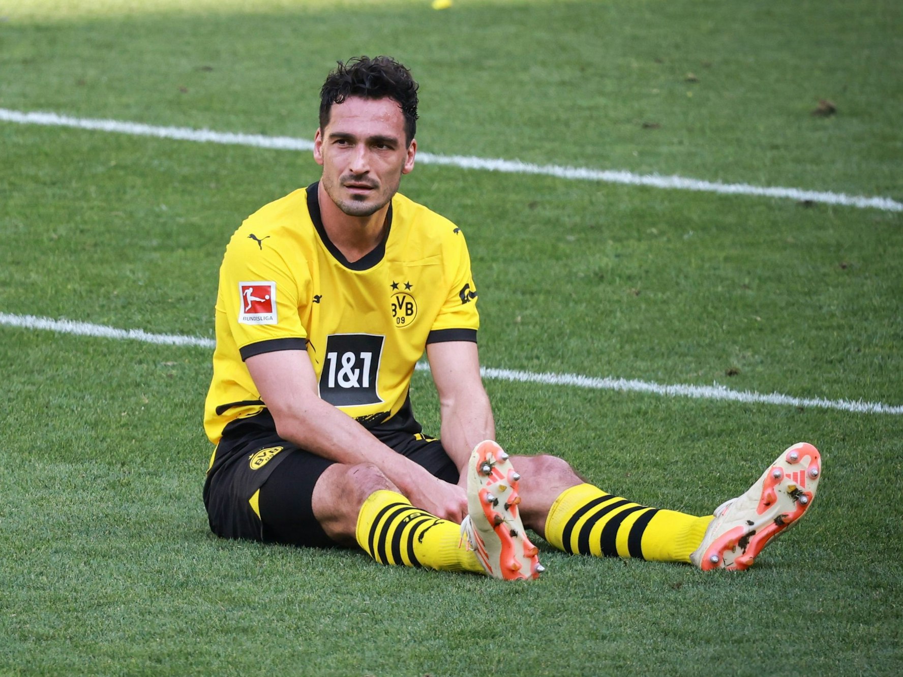 Dortmunds Mats Hummels sitzt nach dem Abpfiff auf dem Rasen.