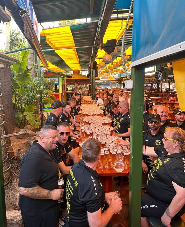 Spieler und Betreuer des FV Bonn-Endenich sitzten an einer langen Tafel, auf der unzählige volle Biergläser stehen.