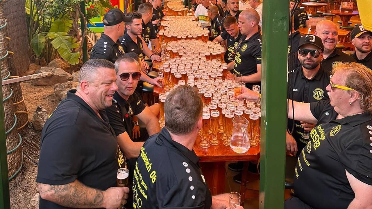 Spieler und Betreuer des FV Bonn-Endenich sitzten an einer langen Tafel, auf der unzählige volle Biergläser stehen.
