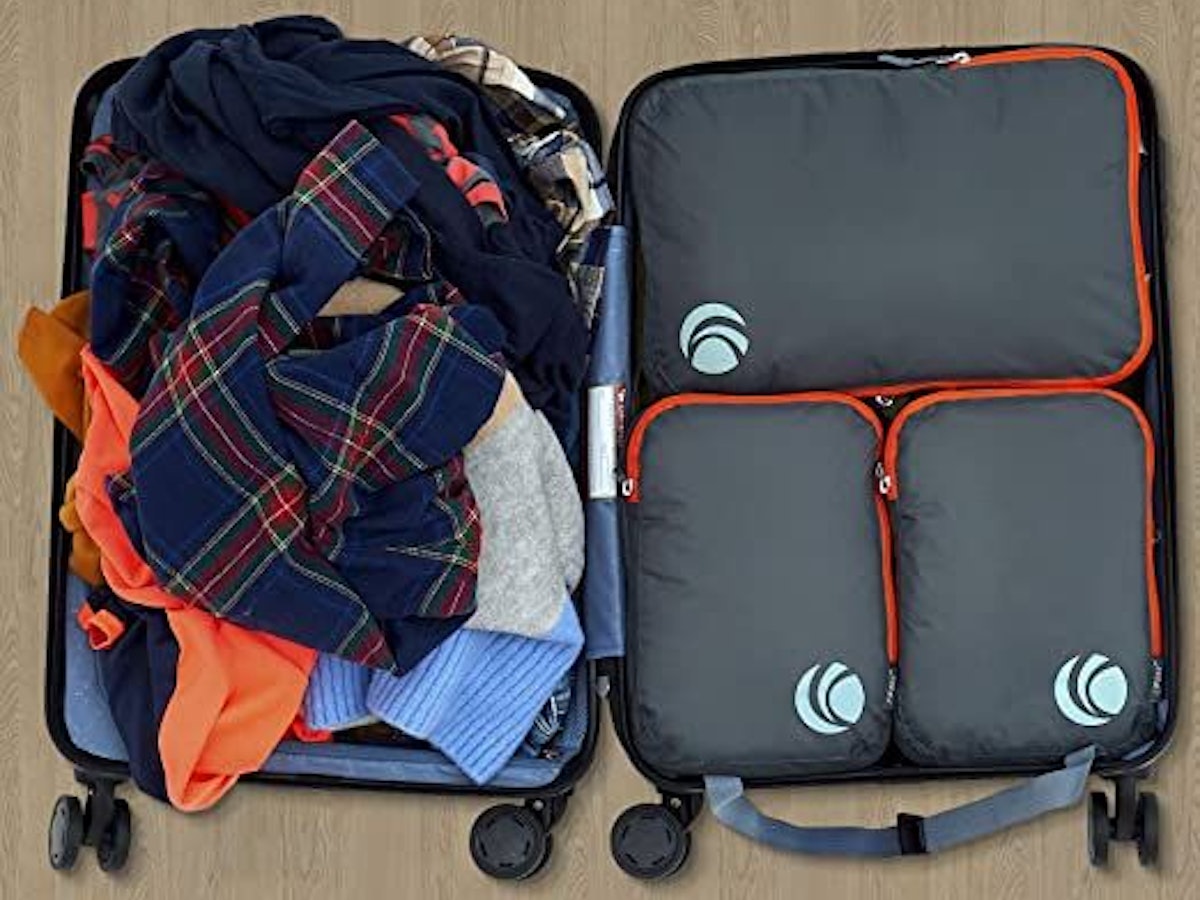 Koffer aufgeklappt mit Klamotten und Packing Cubes.