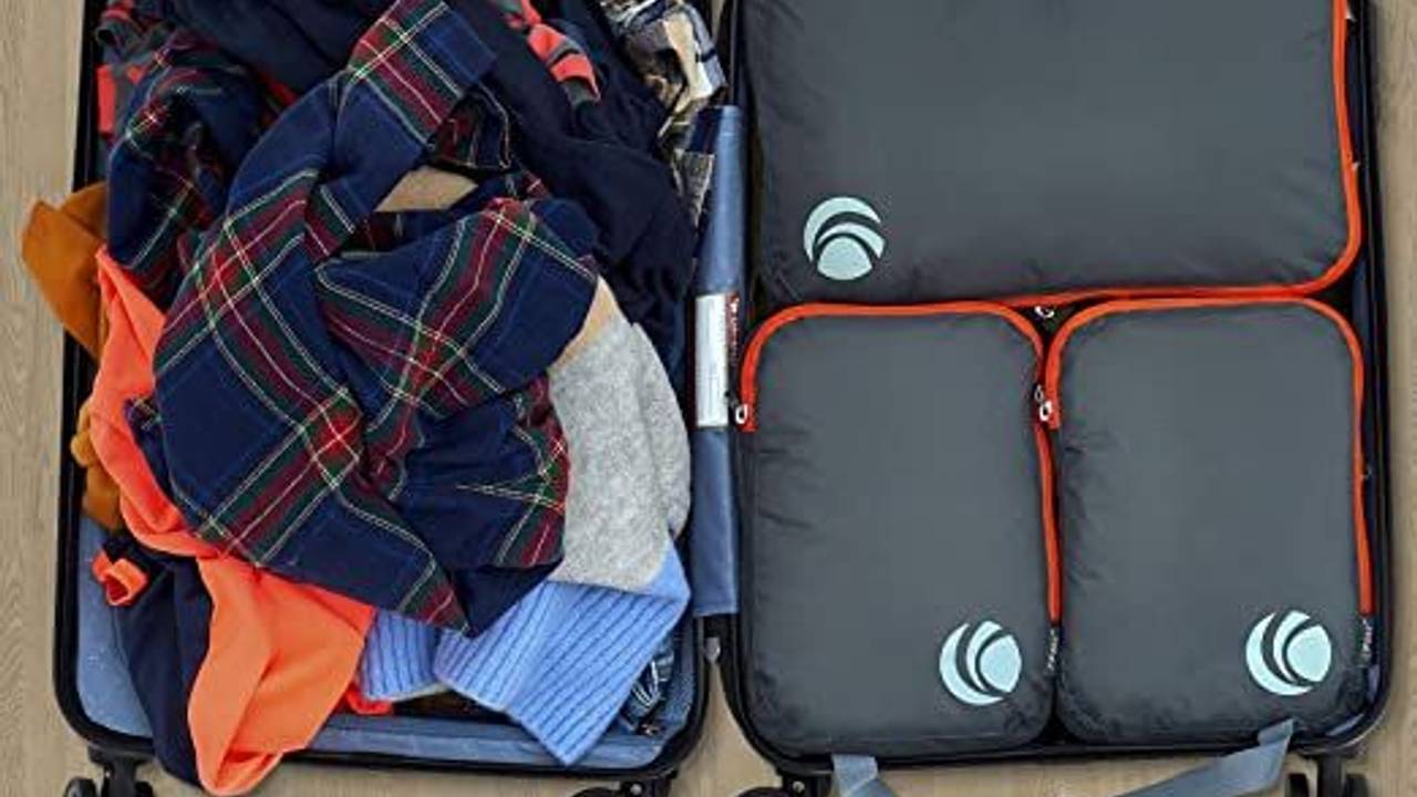 Koffer aufgeklappt mit Klamotten und Packing Cubes.