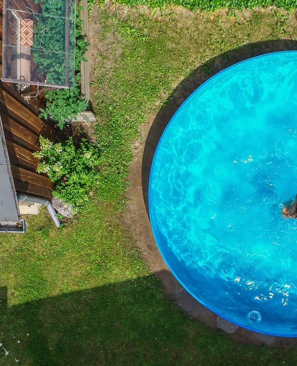 Kinder planschen in einem Pool in einem Garten.