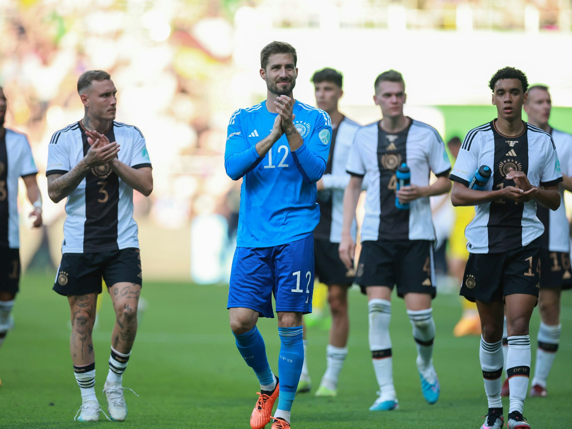 Torwart Kevin Trapp (M.), David Raum (l.) und Jamal Musiala bedanken sich per Applaus bei den Fans.