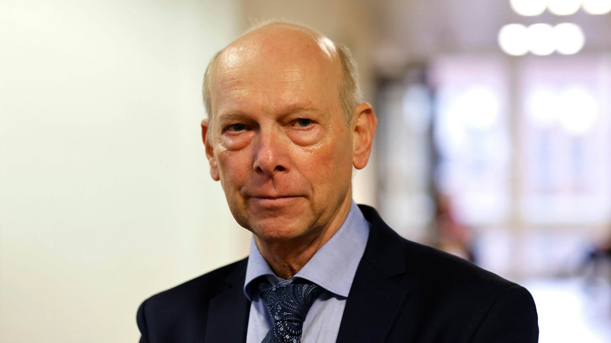 Kläger Georg Menne steht vor der Verhandlung im Landgericht Köln.