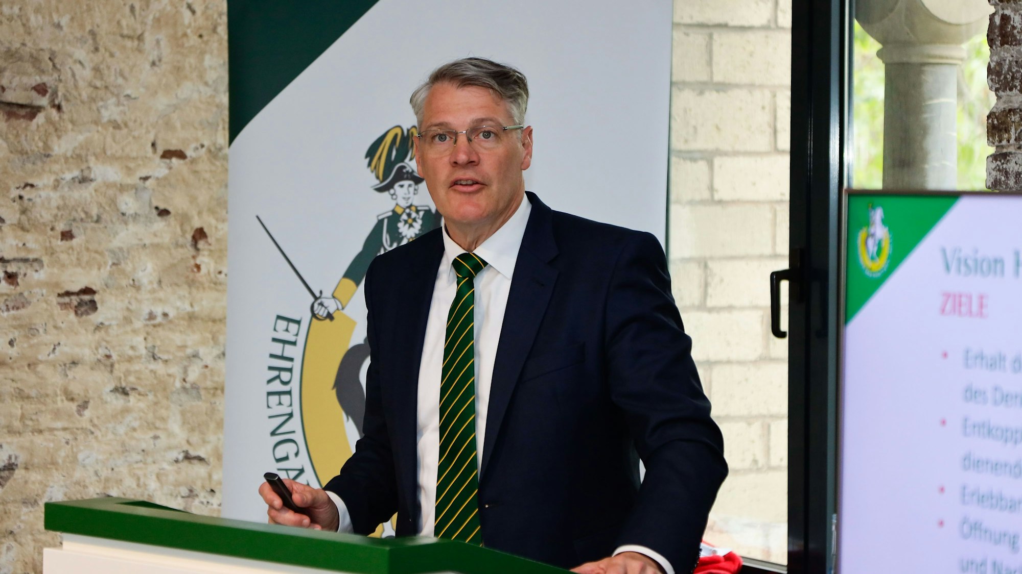 Curt Rehfus steht an einem Pult in der Kölner Hahnentorburg und erklärt die Pläne.