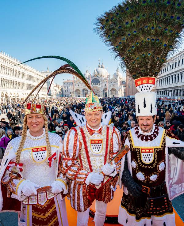 Das Kölner Dreigestirn steht mitten in Venedig und strahlt in die Kamera.