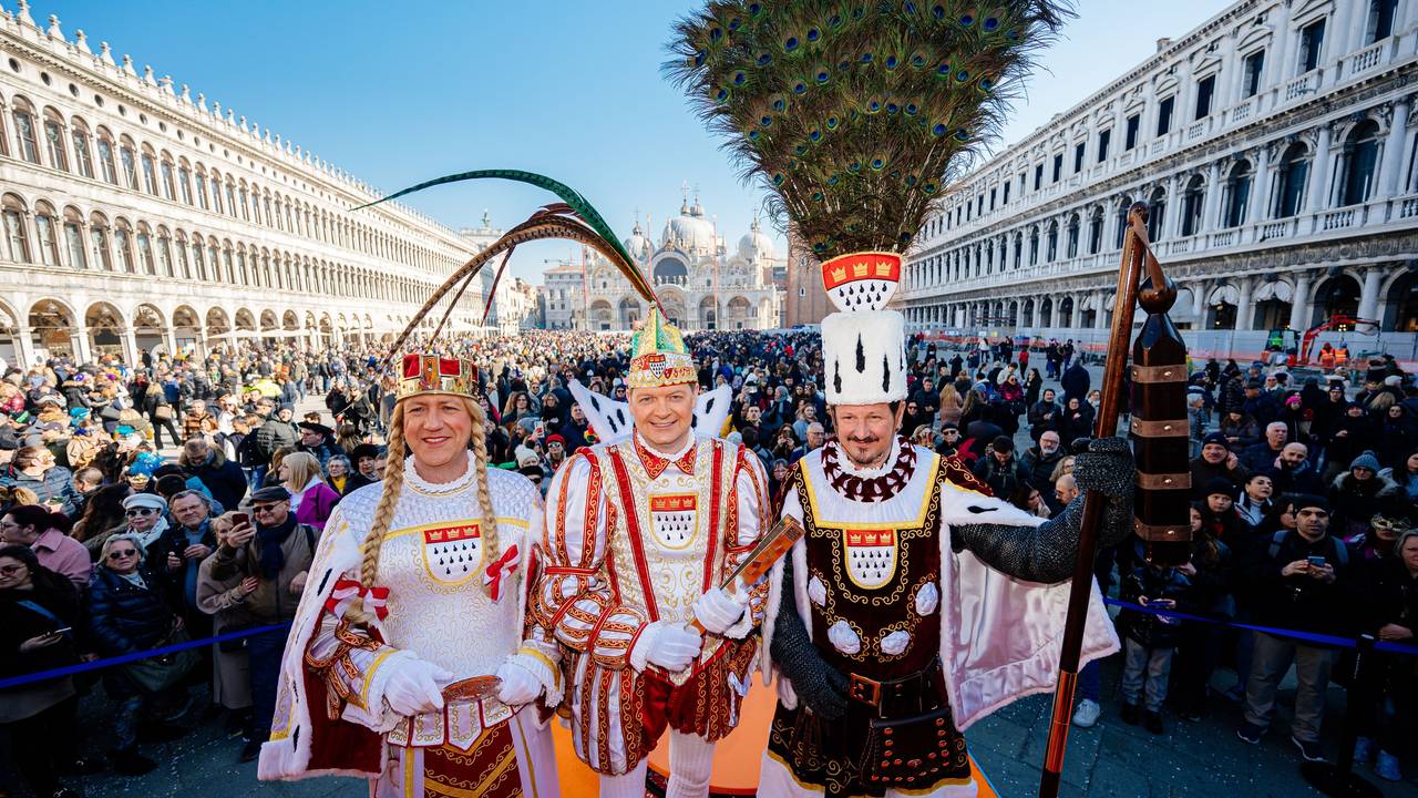 Das Kölner Dreigestirn steht mitten in Venedig und strahlt in die Kamera.