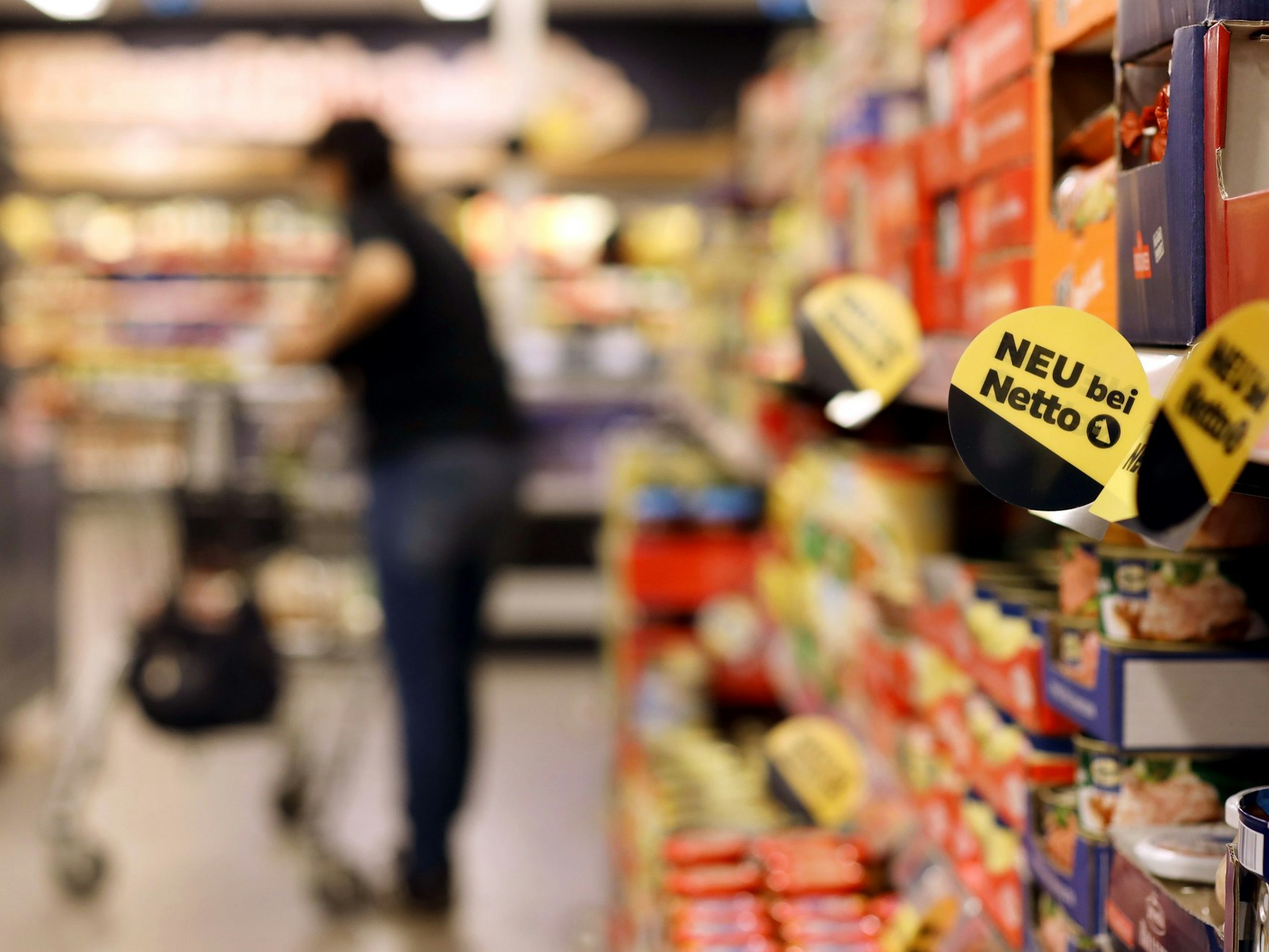 Eine Kundin geht in einer Filiale der Handelskette Netto ApS & Co. KG an den Regalen entlang.