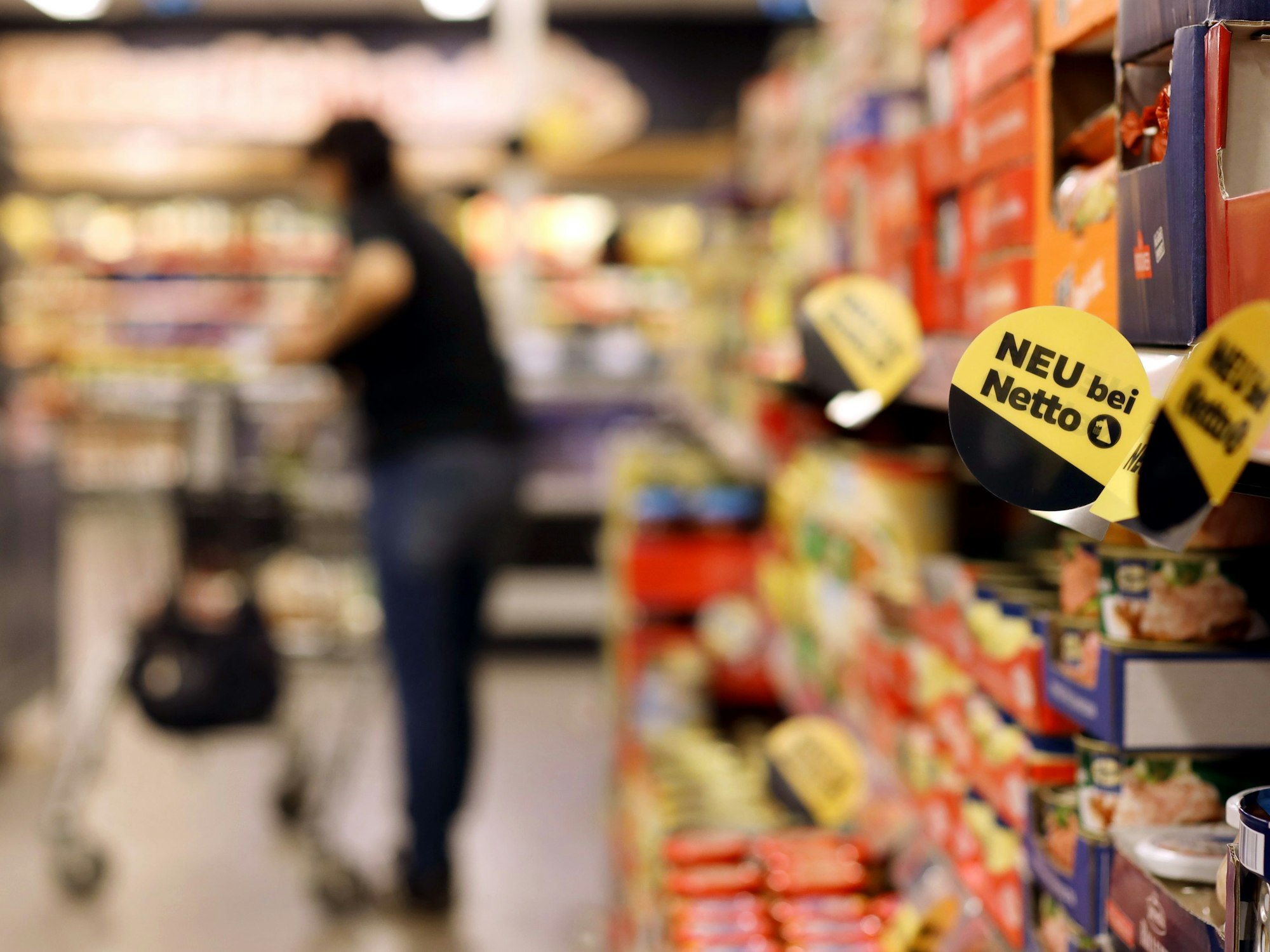 Eine Kundin geht in einer Filiale der Handelskette Netto ApS & Co. KG an den Regalen entlang.