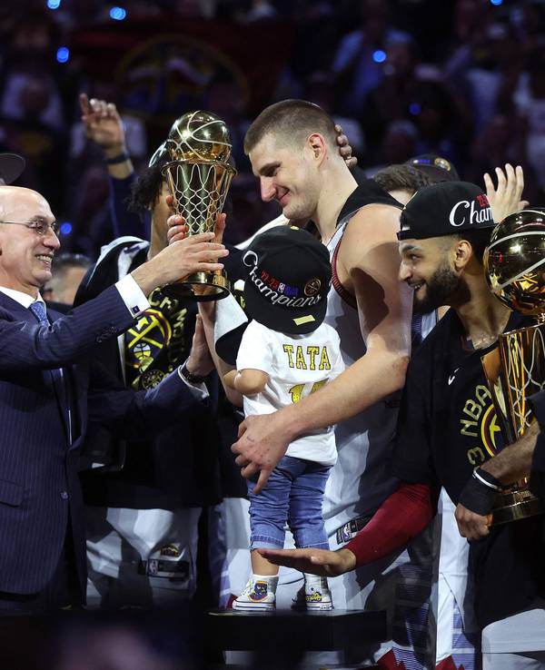 Nikola Jokic (Mitte) nimmt nach dem NBA-Titel mit den Denver Nuggets die Trophäe für den Finals-MVP entgegen.