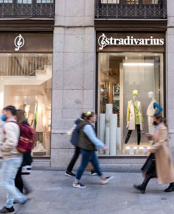 Menschen gehen an einem Schaufenster eines Stradivarius-Geschäfts vorbei, das zur Inditex-Gruppe gehört, hier im März 2022 in Madrid.