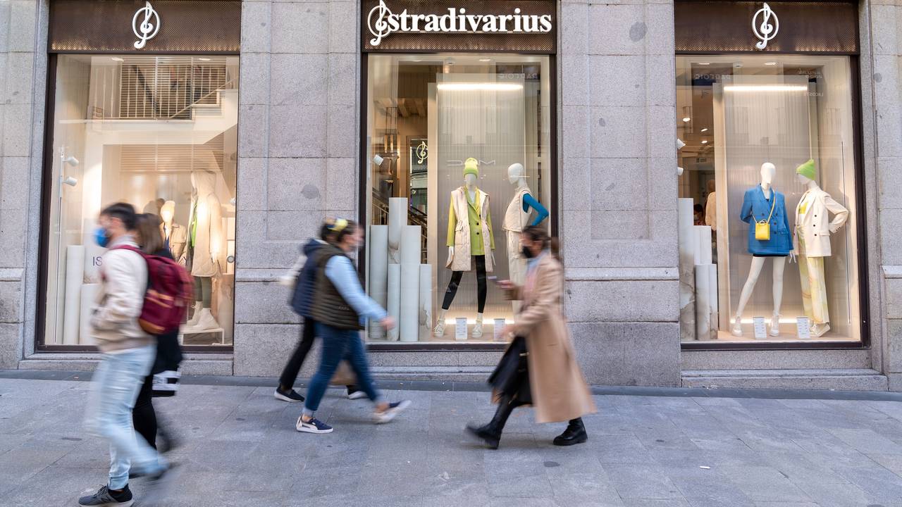 Menschen gehen an einem Schaufenster eines Stradivarius-Geschäfts vorbei, das zur Inditex-Gruppe gehört, hier im März 2022 in Madrid.