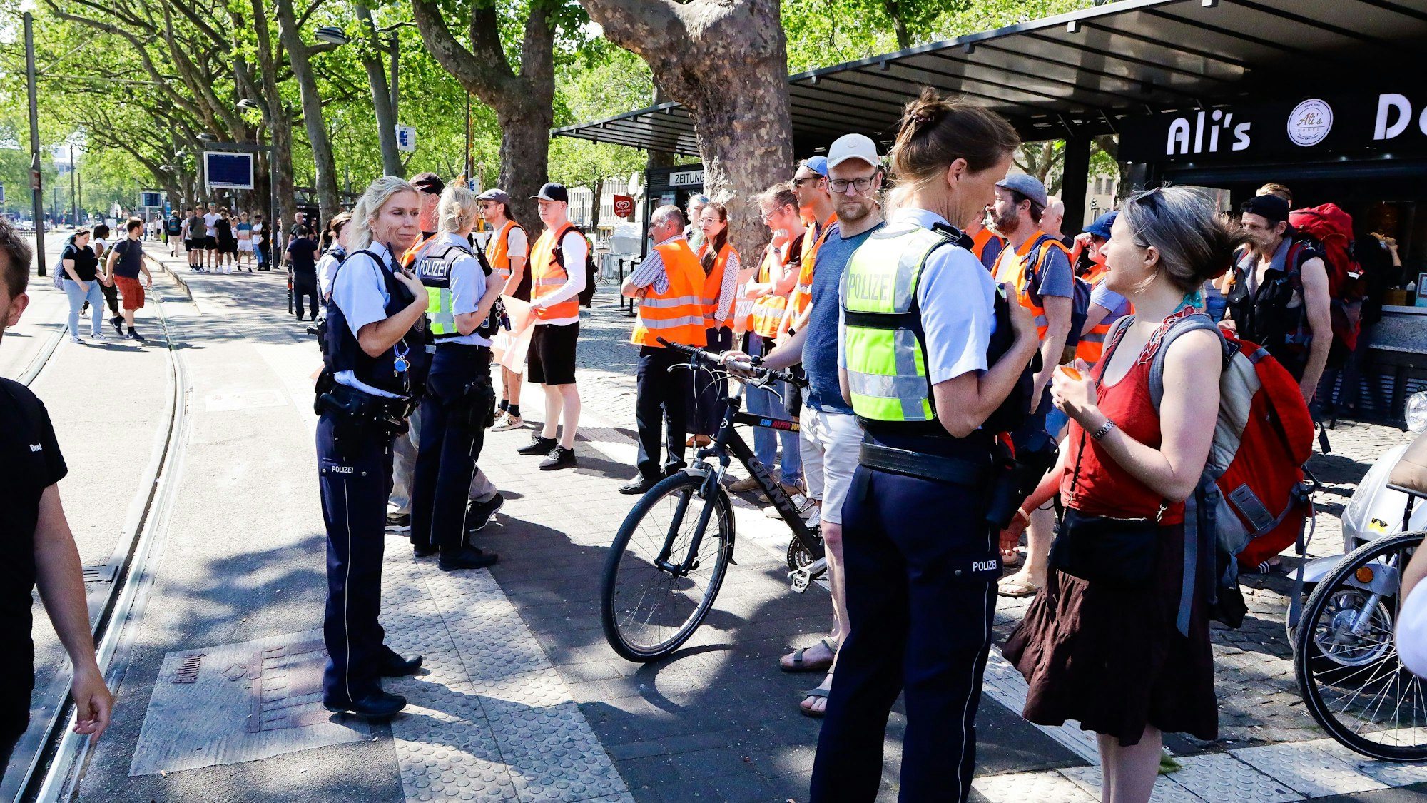Polizei diskutiert mit Aktivistinnen und Aktivisten der „Letzten Generation“ auf der Straße.