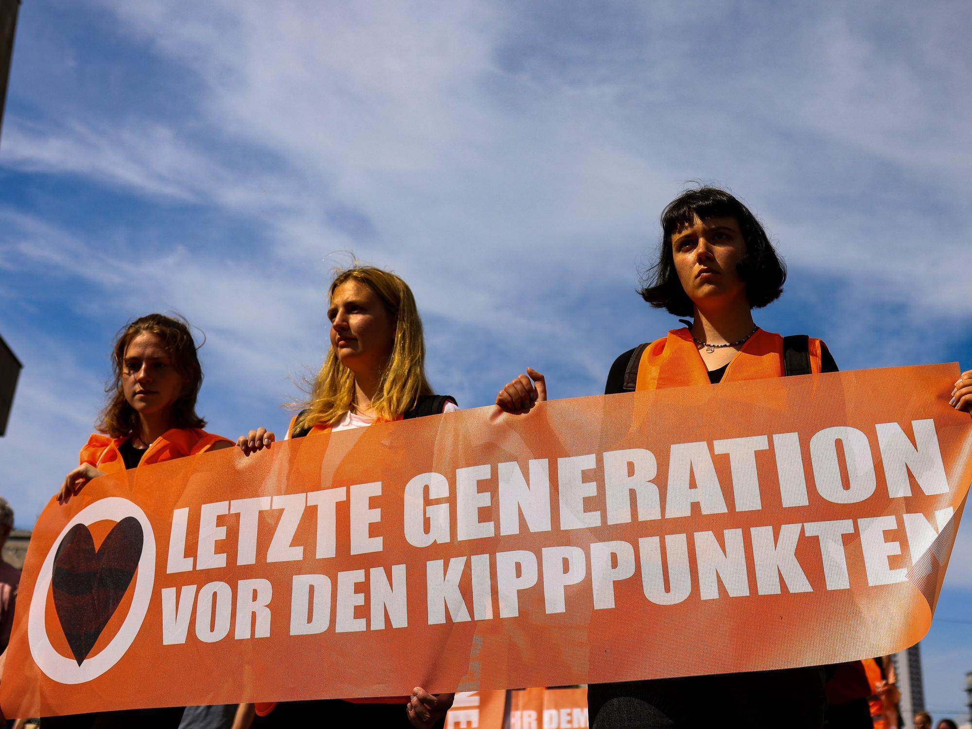 Teilnehmer und Teilnehmerinnen eines Protestmarsches der Letzten Generation gehen um den Leipziger Ring und halten Banner in der Hand, hier im Mai 2023.
