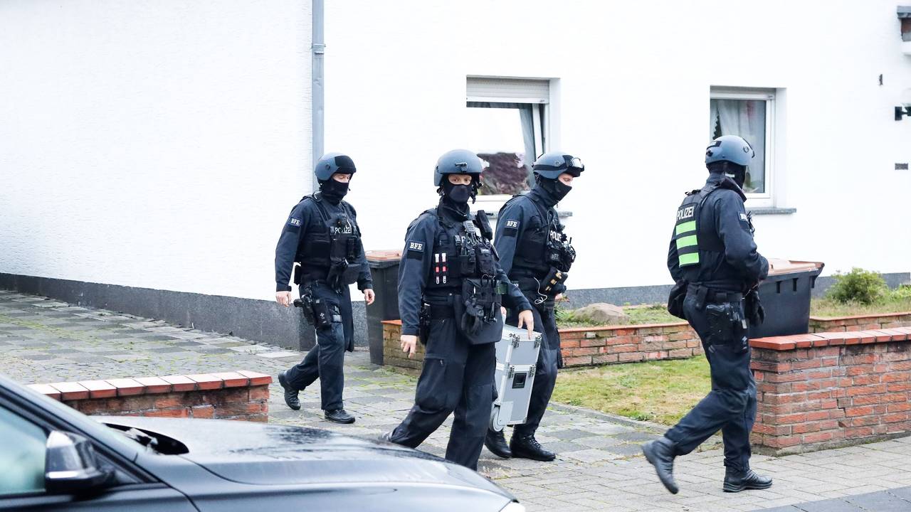 Einsatzkräfte der Polizei bei einer Razzia in einer Einfahrt in Köln.