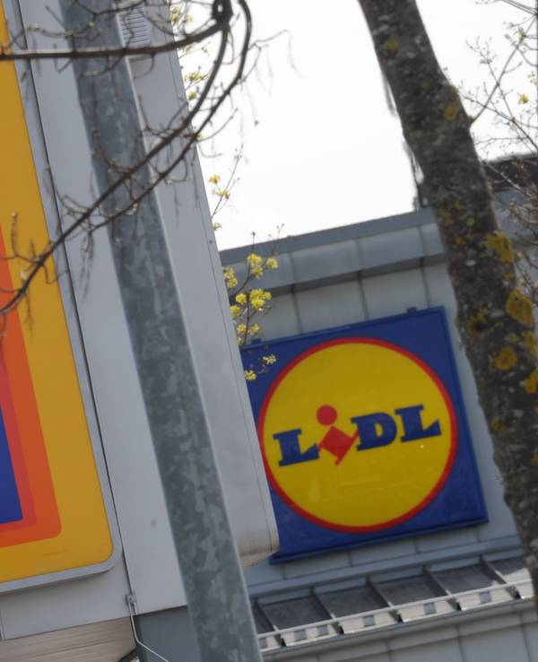 Die Logos der Discount-Supermärkte Aldi und Lidl hängen am 21. April 2012 in Unterhaching bei München (Oberbayern) an zwei Filialen der Unternehmen, die in unmittelbarer Nachbarschaft stehen.