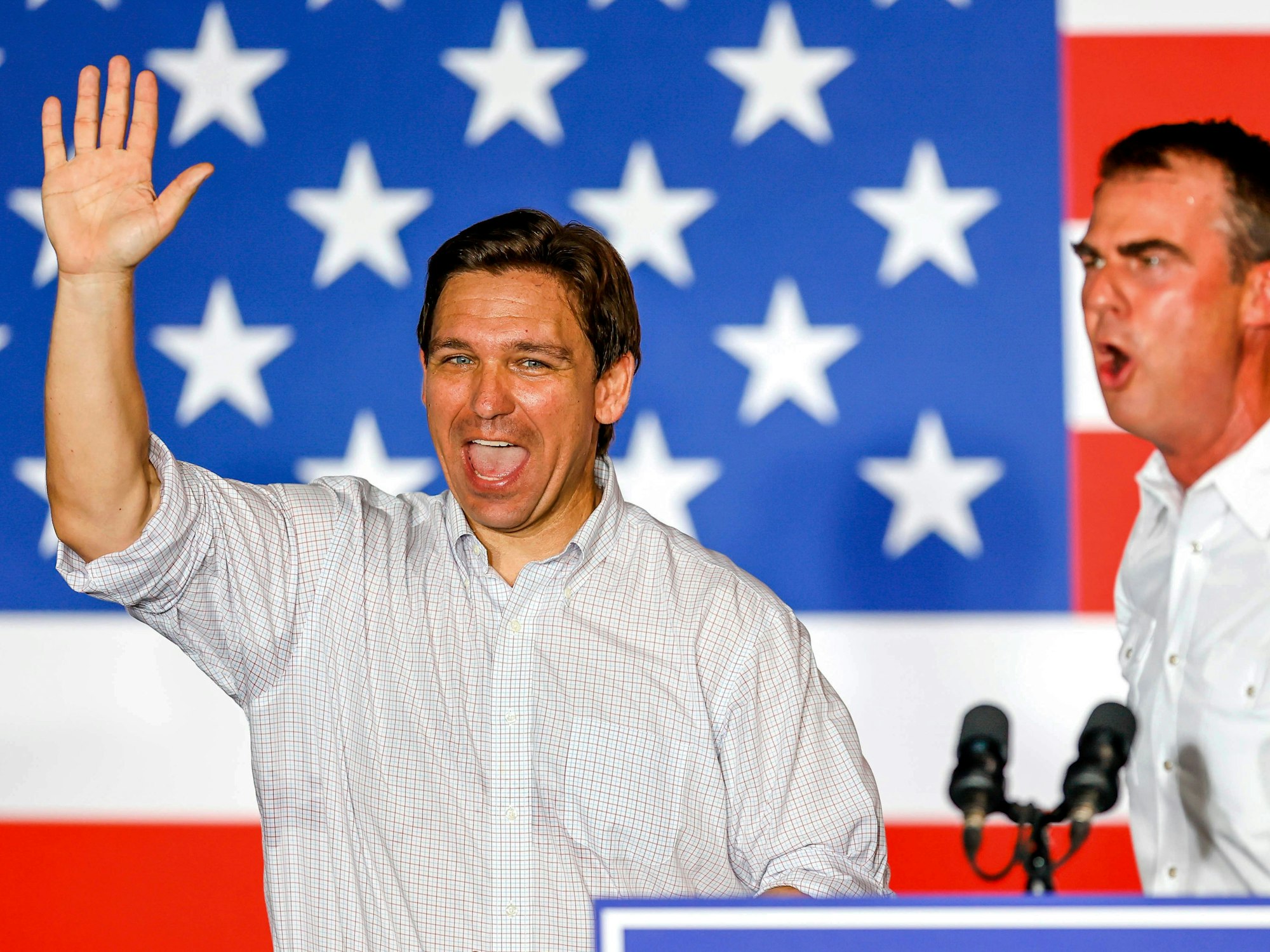 Ron DeSantis (links), Gouverneur von Florida und Präsidentschaftskandidat der Republikaner, winkt am 10. Juni 2023 der Menge neben Kevin Stitt, Gouverneur des US-Bundesstaats Oklahoma, bei einer Veranstaltung des Never Back Down PAC in Tulsa (Oklahoma) zu.