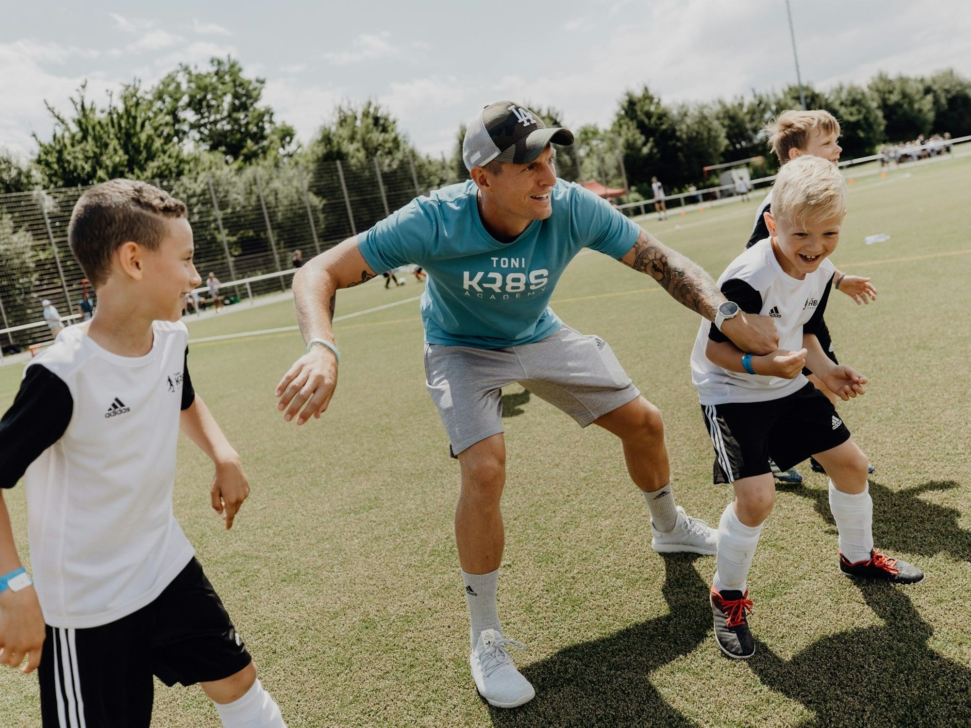 Toni Kroos spielt mit Kindern Fußball.