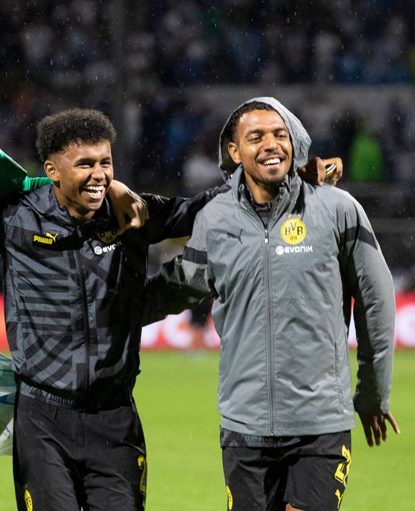 Dortmunds Julian Brandt, Torhüter Gregor Kobel, Karim Adeyemi und Donyell Malen von links feiern den Sieg vor der Fankurve.