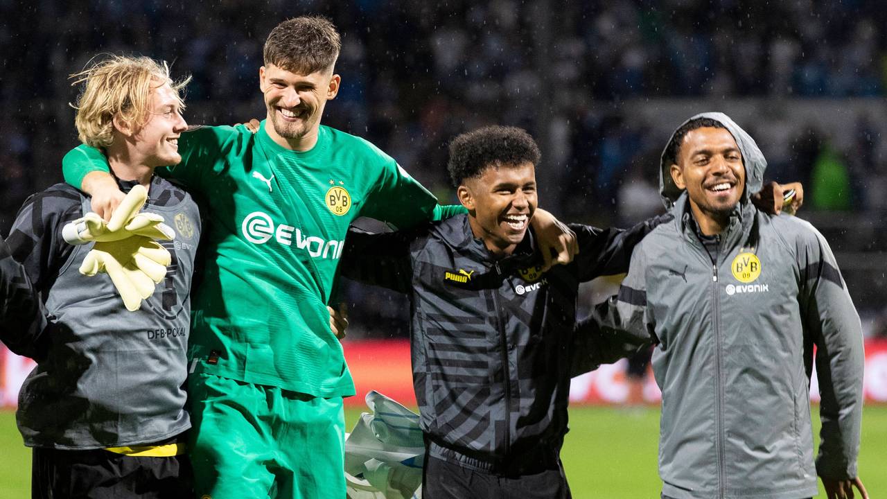 Dortmunds Julian Brandt, Torhüter Gregor Kobel, Karim Adeyemi und Donyell Malen von links feiern den Sieg vor der Fankurve.