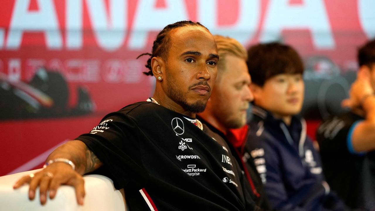Lewis Hamilton sitzt entspannt auf einem Sofa.