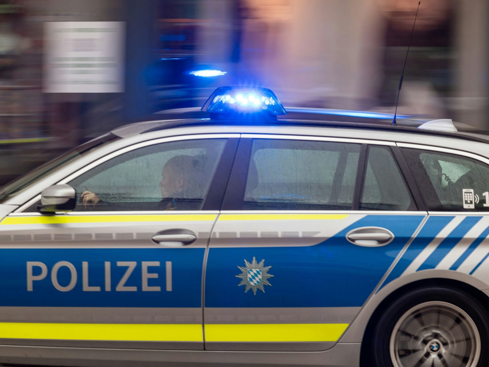Ein Polizeiwagen fährt mit Blaulicht durch die Innenstadt.