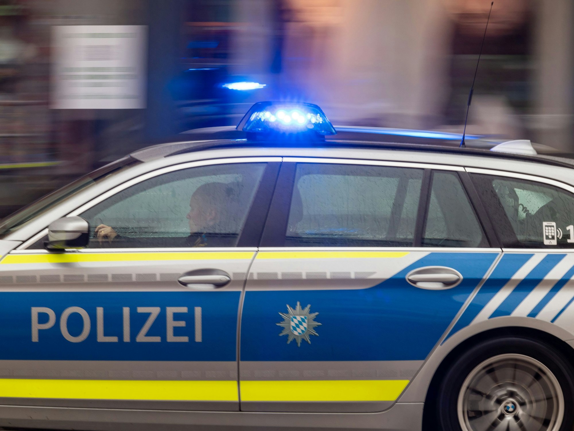 Ein Polizeiwagen fährt mit Blaulicht durch die Innenstadt.
