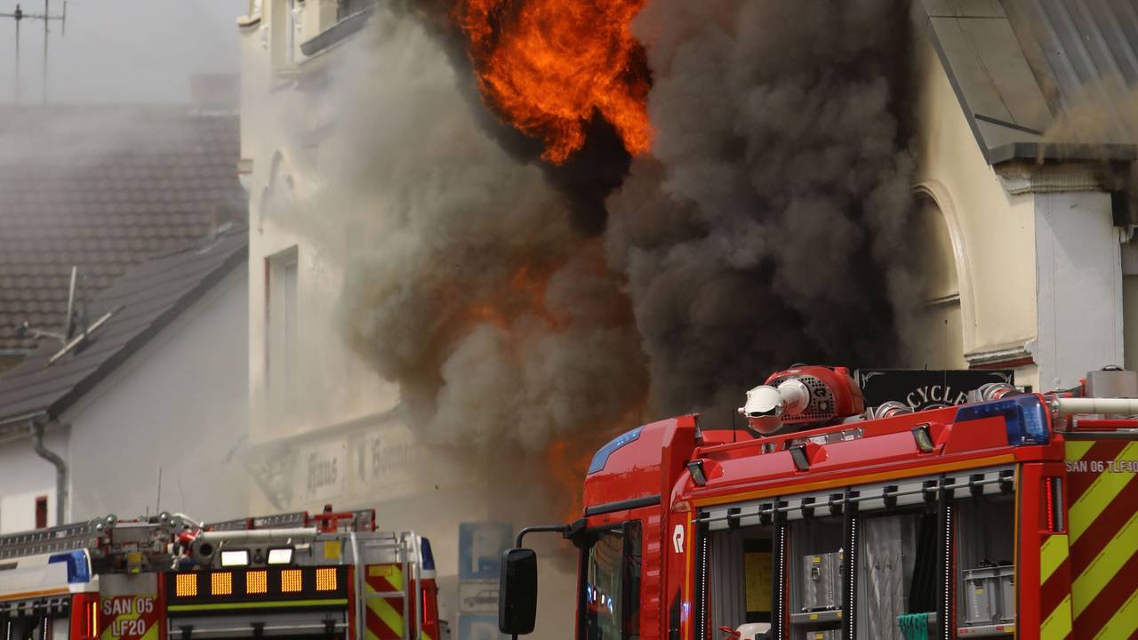 Flammen schlagen aus einem Dach. Ein Motorradladen ist in Sankt Augustin im Rhein-Sieg-Kreis in Brand geraten.