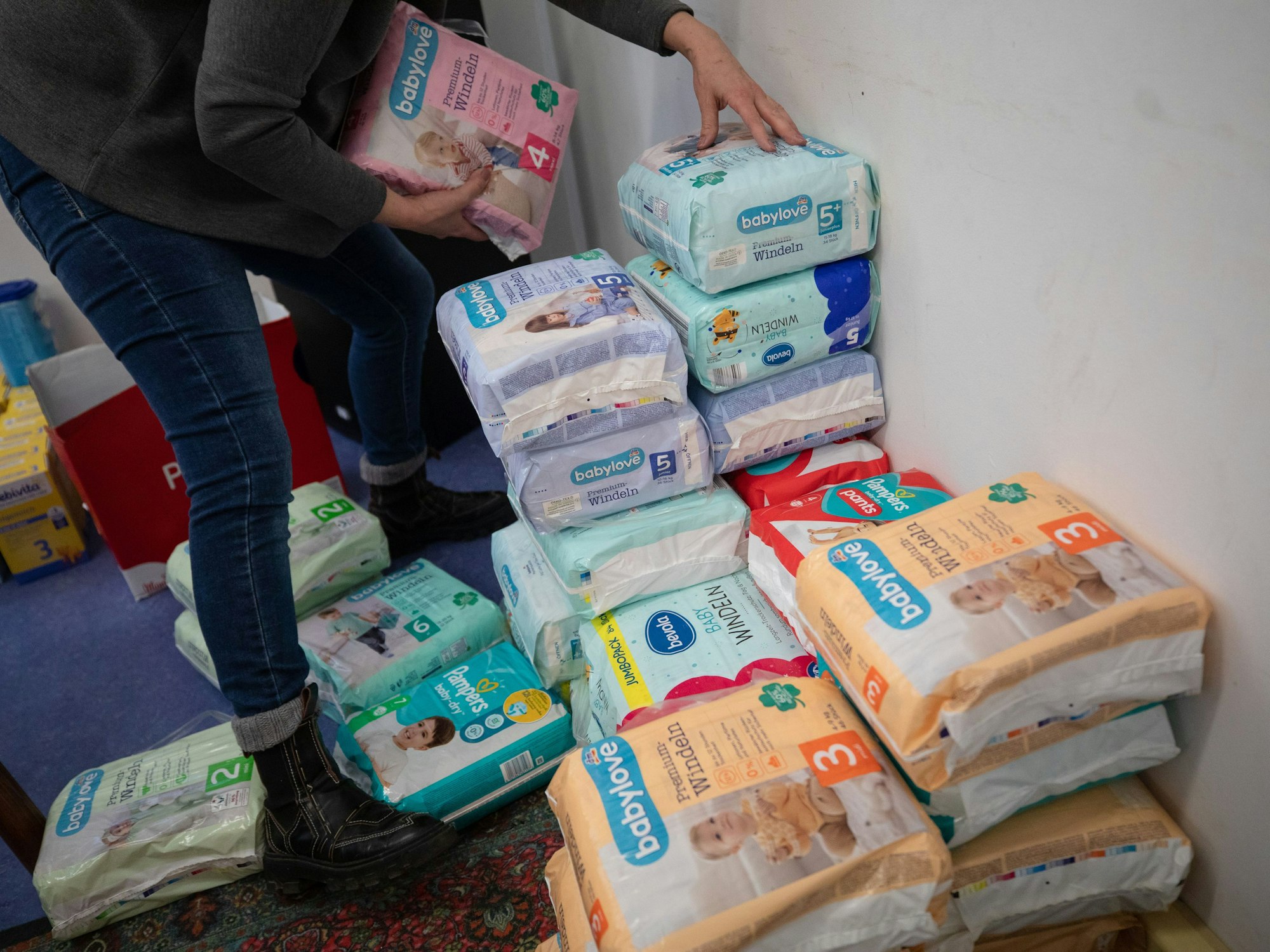 In einem Raum der Kultur- und Sozialinitiative für Kinder und Jugendliche Stuttgart, sortiert eine Frau Windeln, hier im Februar 2023.