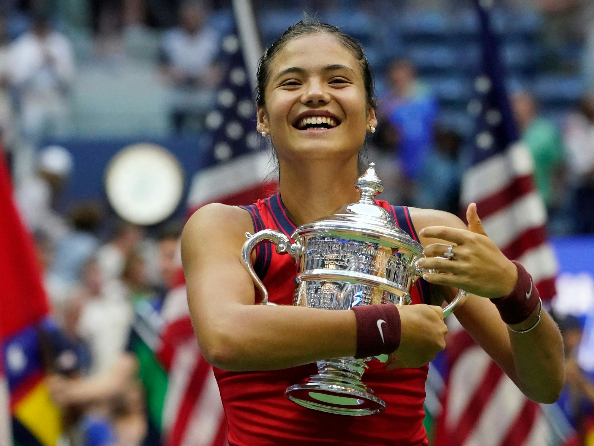 Emma Raducanu hält bei den US Open die Trophäe in den Armen.