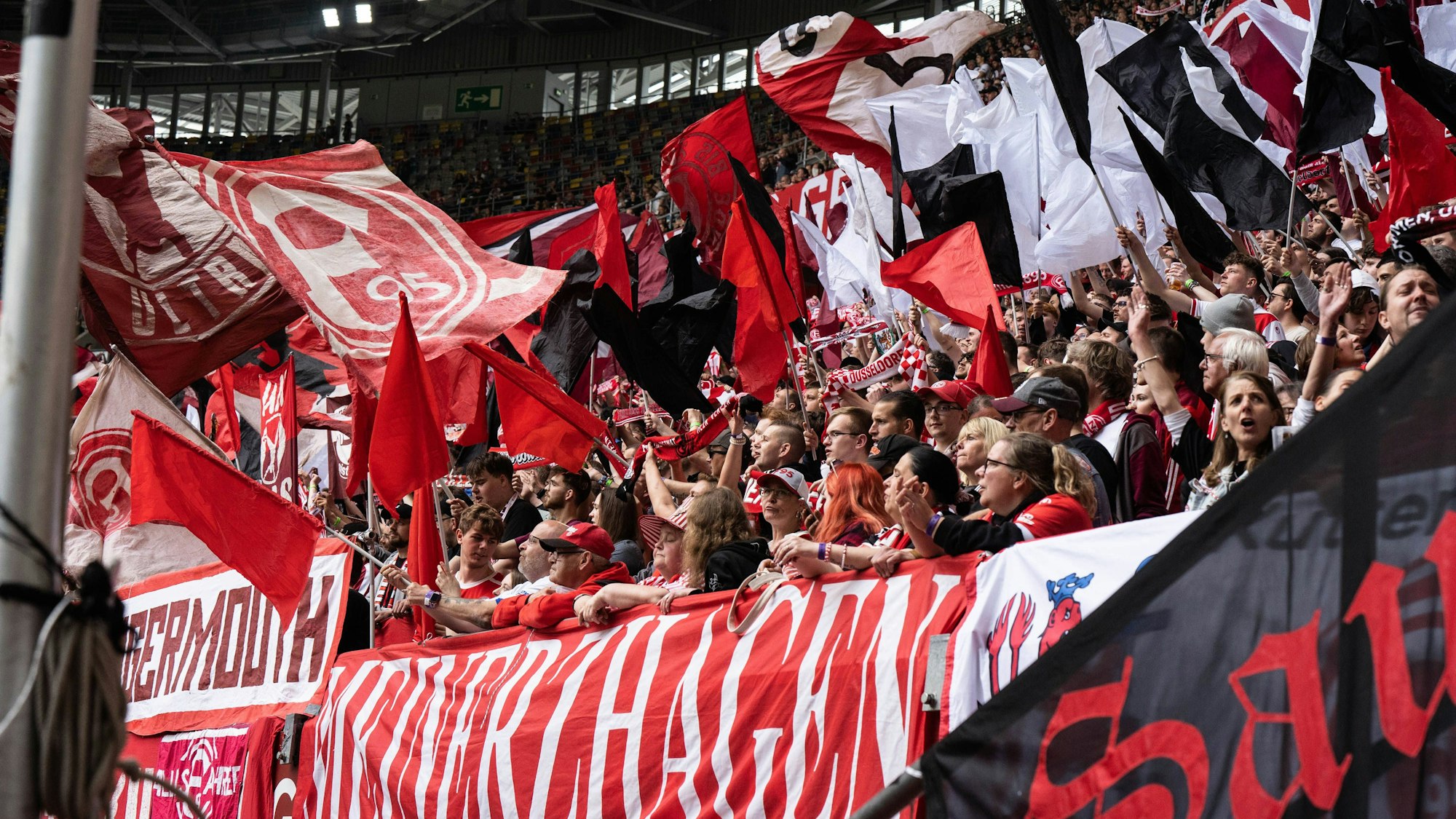 Fans von Fortuna Düsseldorf schwenken ihre Fahnen beim Heimspiel gegen Holstein Kiel.