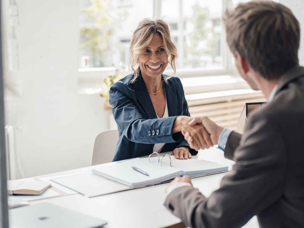 Frau und Mann schütteln sich die Hände.