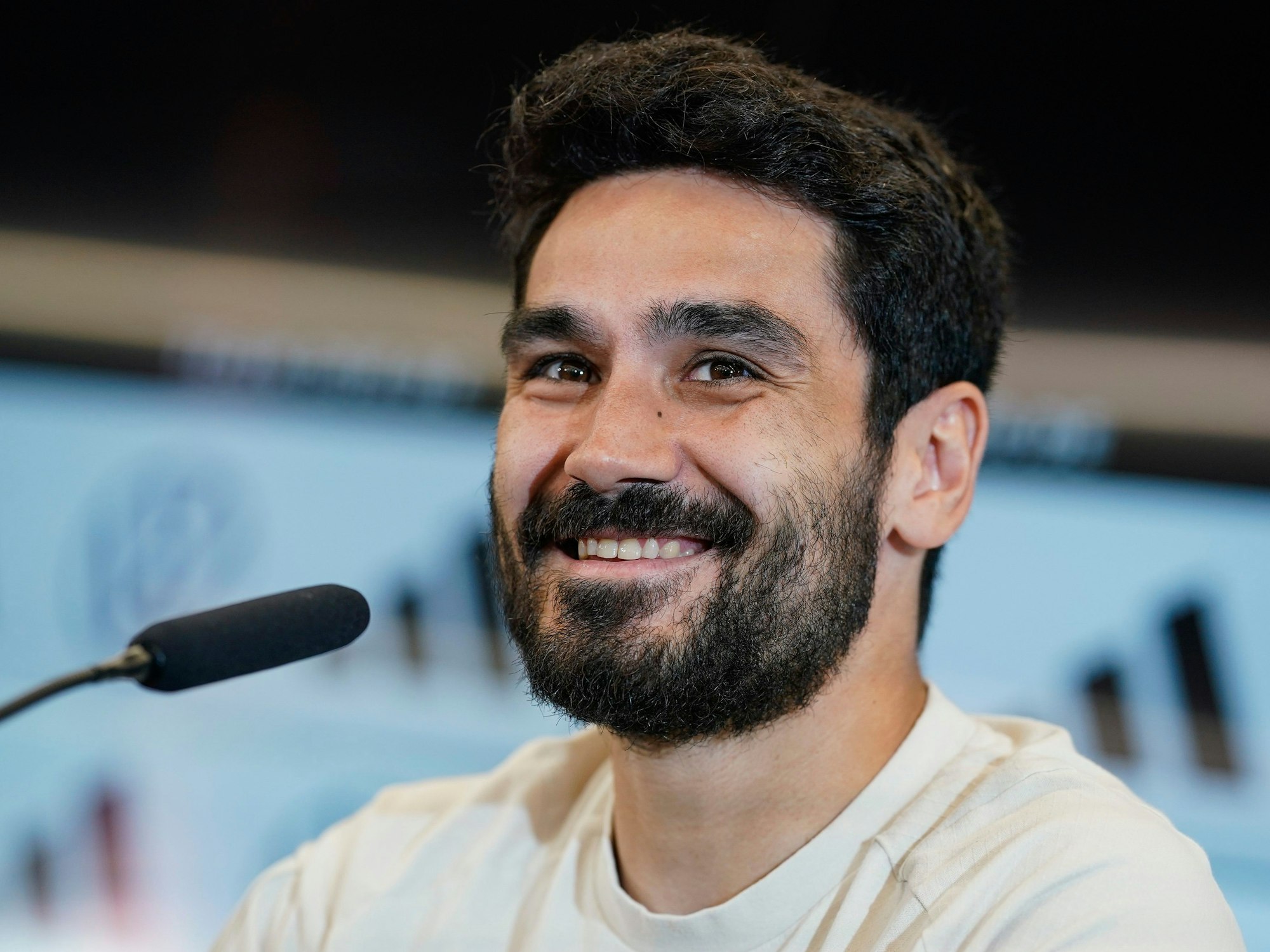 Ilkay Gündogan sitzt auf dem Podium.