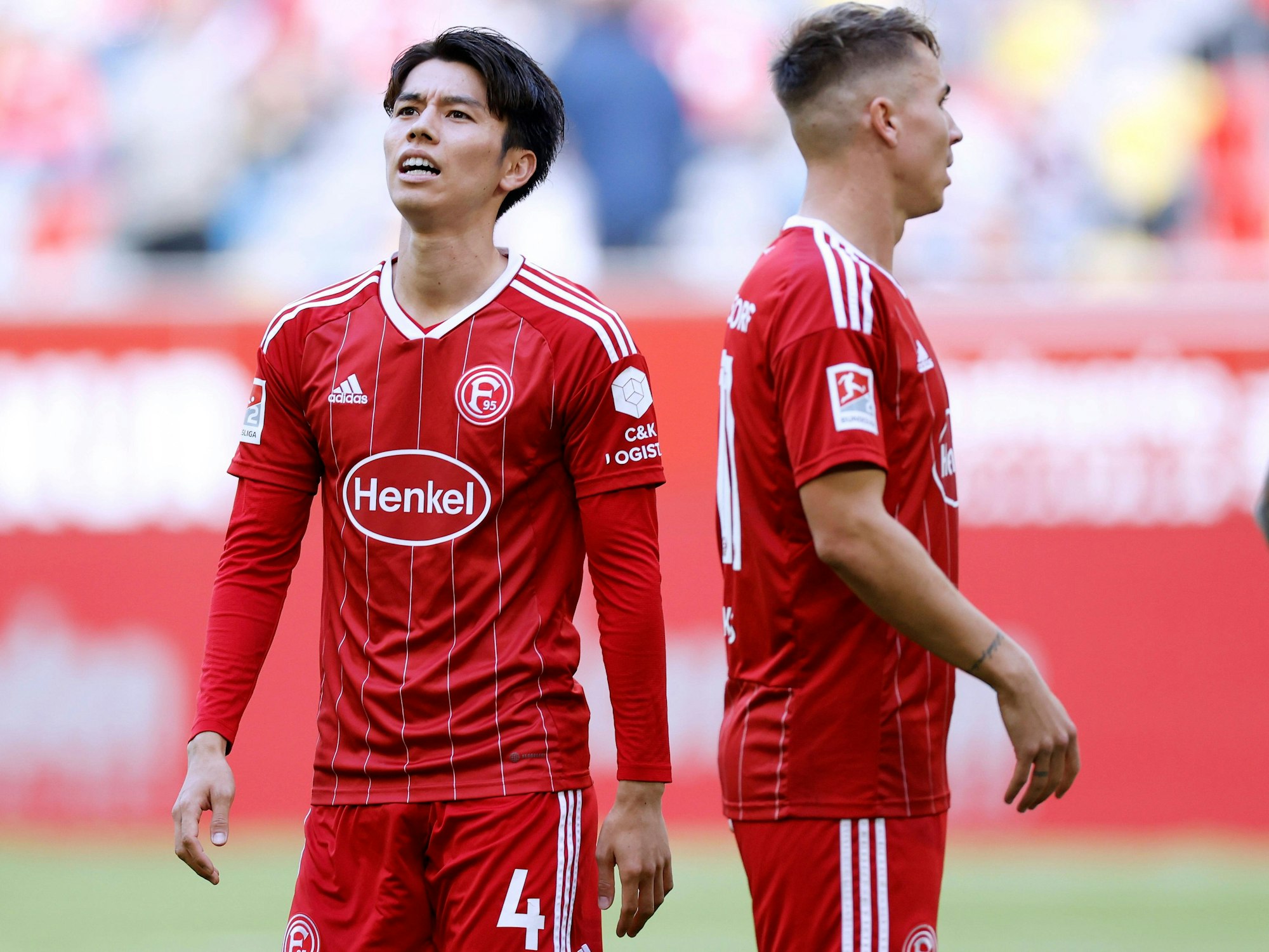 Ao Tanaka und Felix Klaus stehen beim Spiel gegen Arminia Bielefeld auf dem Rasen.
