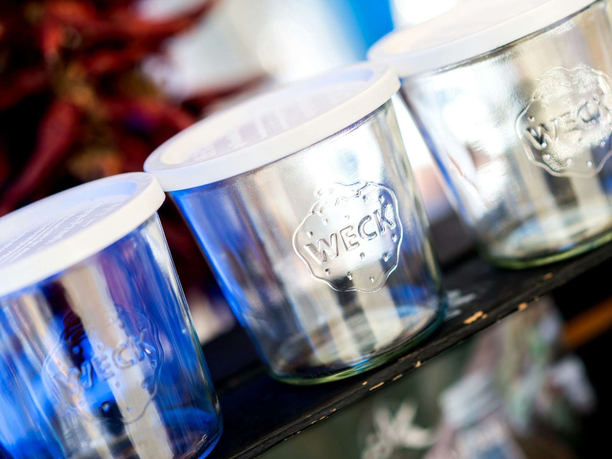 Wiederverwendbare Gläser stehen an einem Stand auf einem Wochenmarkt.