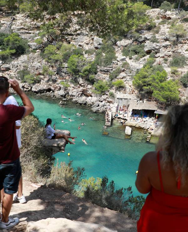 Menschen baden am Strand Cala Pi an einem heißen Sommertag.